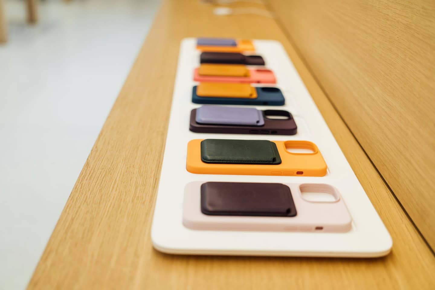 Cover colorate per smartphone e portafogli magnetici abbinati su un vassoio bianco.